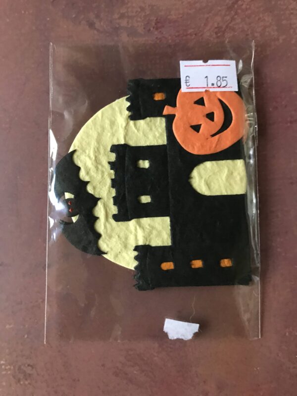 Die cuts of a spooky castle with pumpkin and bat on a moon background.